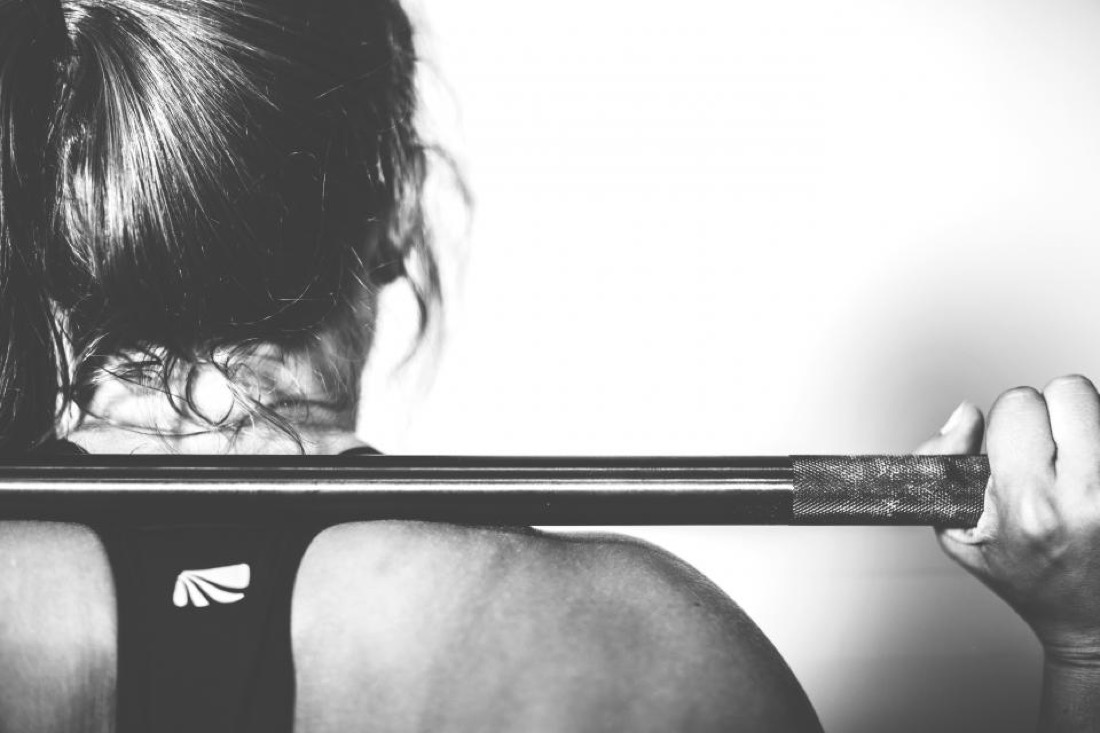 A lifter racking a barbell across the shoulders