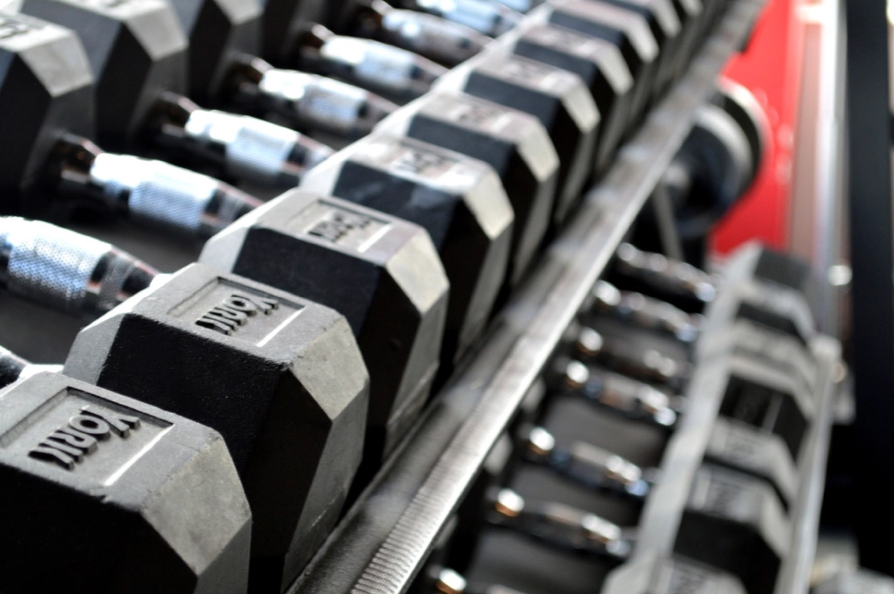A rack of dumbbells in a dimly lit gym